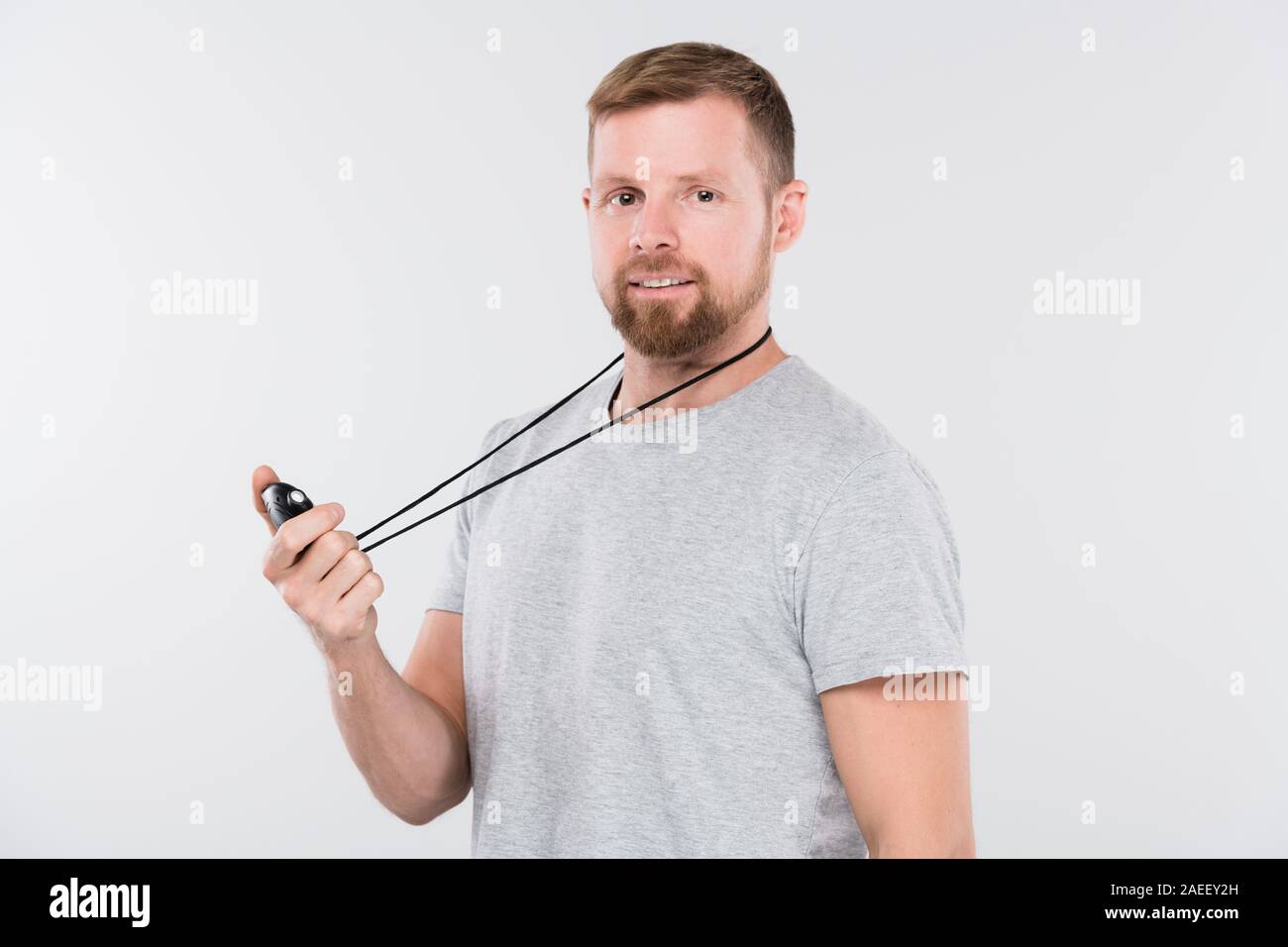 Giovane sportivo barbuto con cronometro controllo risultati in esecuzione durante il corso di formazione Foto Stock