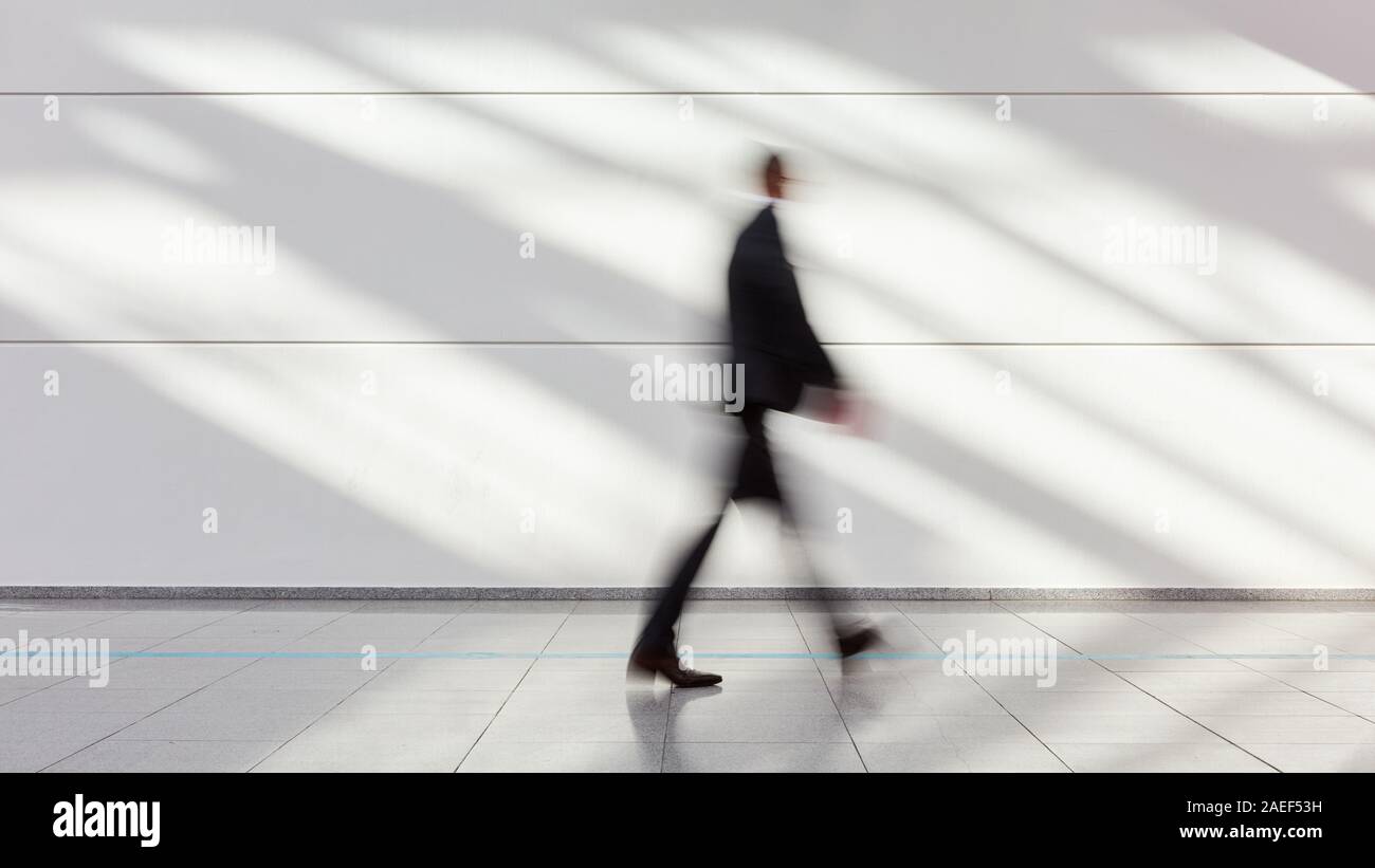 Anonimo imprenditore sfocata ingranaggio va in ufficio o in una fiera commerciale Foto Stock