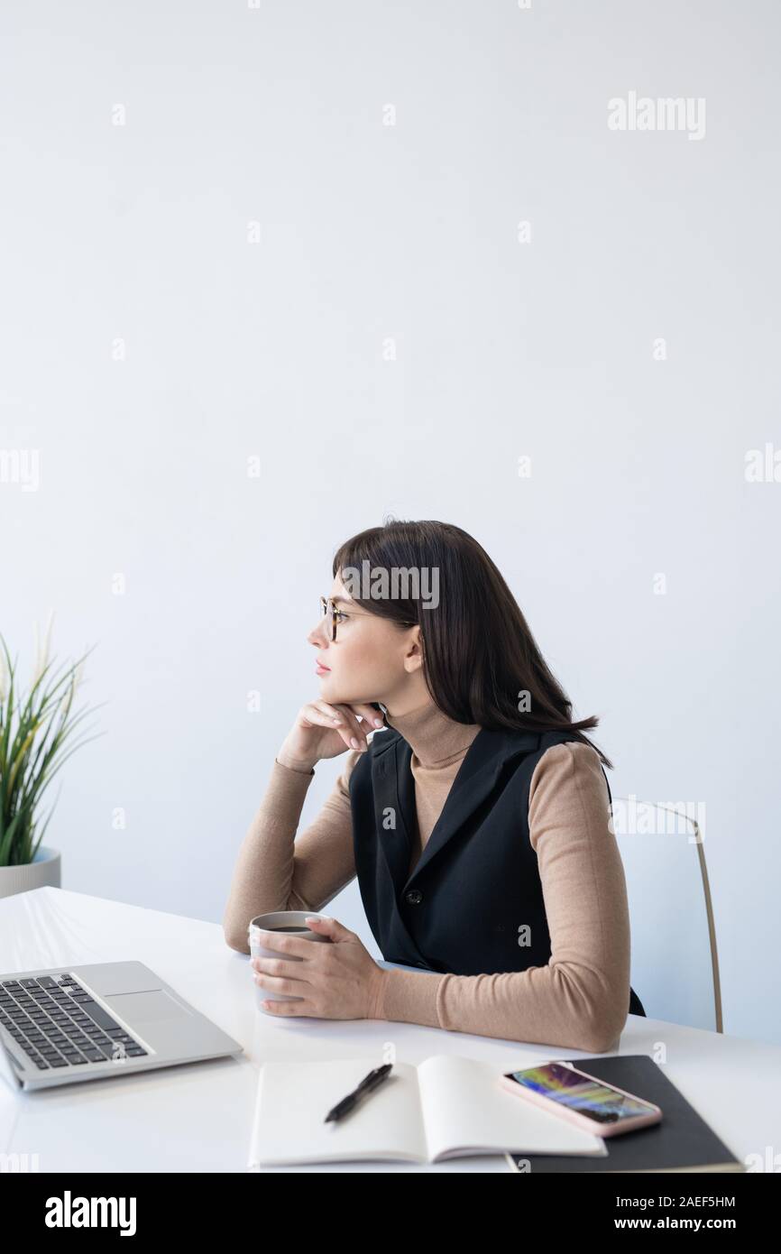 Malinconici analista femmina di pensare a come affrontare la situazione finanziaria Foto Stock