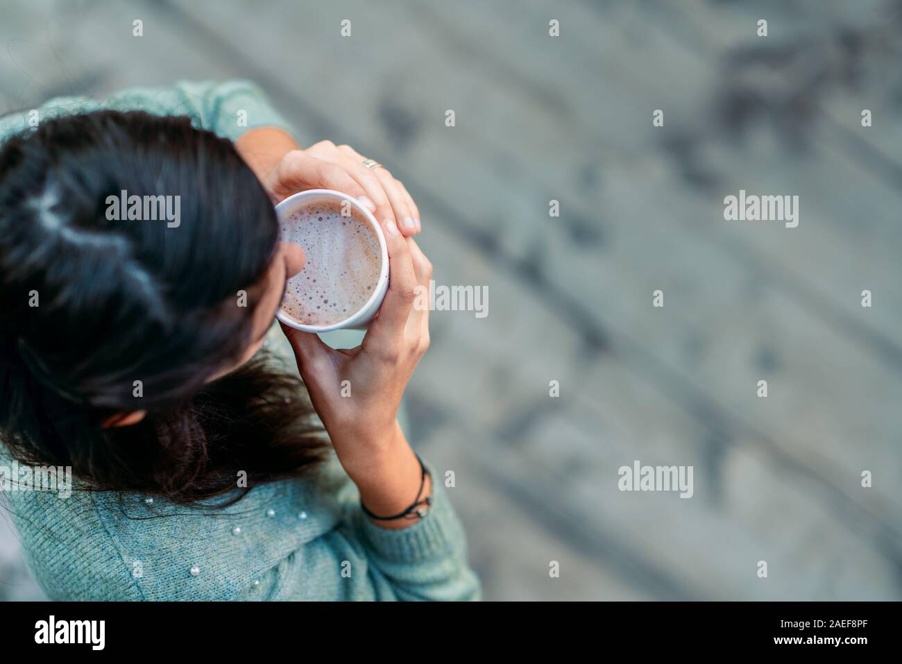 Donna che mantiene un bicchiere di carta di un delizioso caffè. Foto Stock