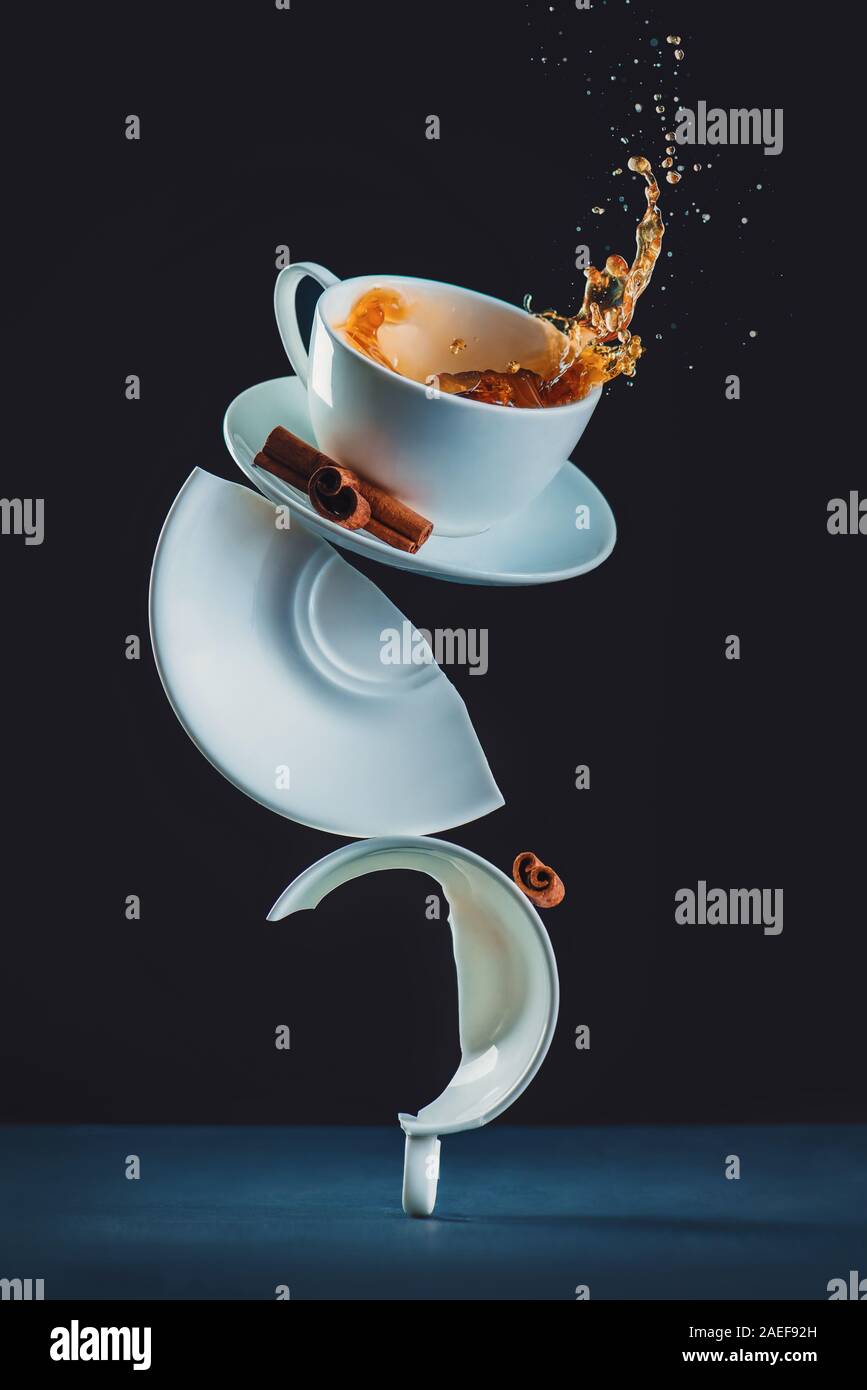 Composizione di bilanciamento di tazze da caffè e da schizzi, rotture di piatti e la cannella. Creative fotografia di caffè Foto Stock