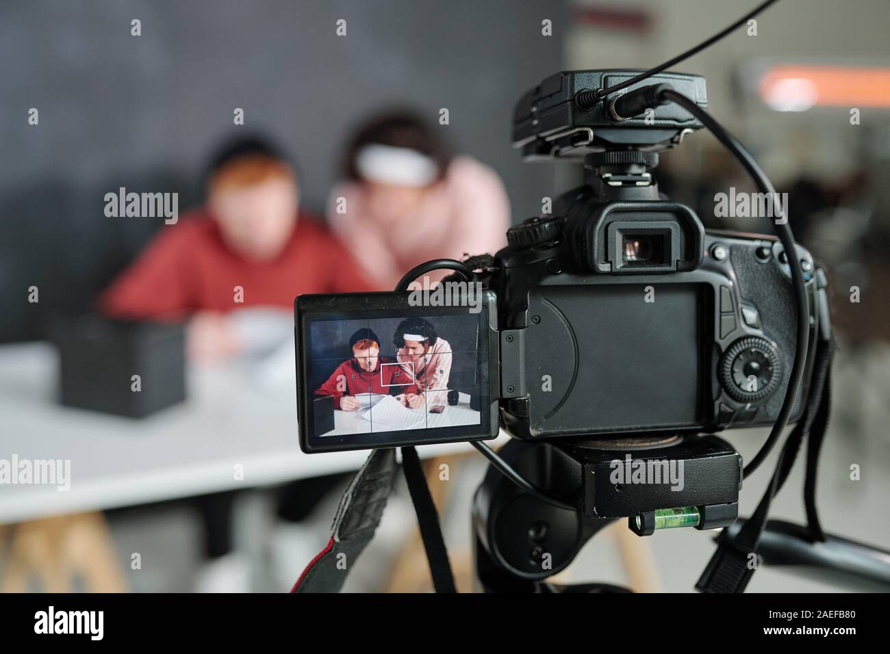 Due giovani contemporanei vloggers maschio sullo schermo della telecamera video in studio Foto Stock