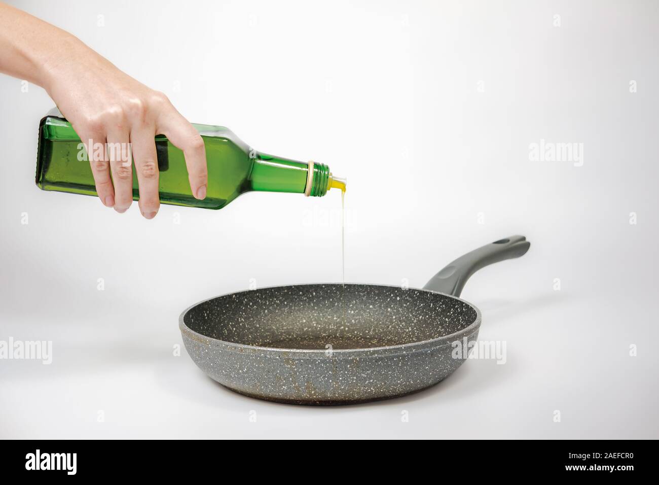 Versando olio su una padella. La cottura con olio vegetale, concetto di grasso dieta ricca o malsane mangiare Foto Stock