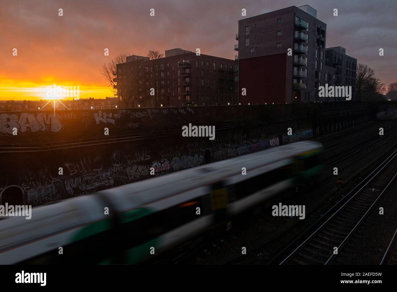 A sud del treno si avvicina Clapham Junction al sorgere del sole Foto Stock