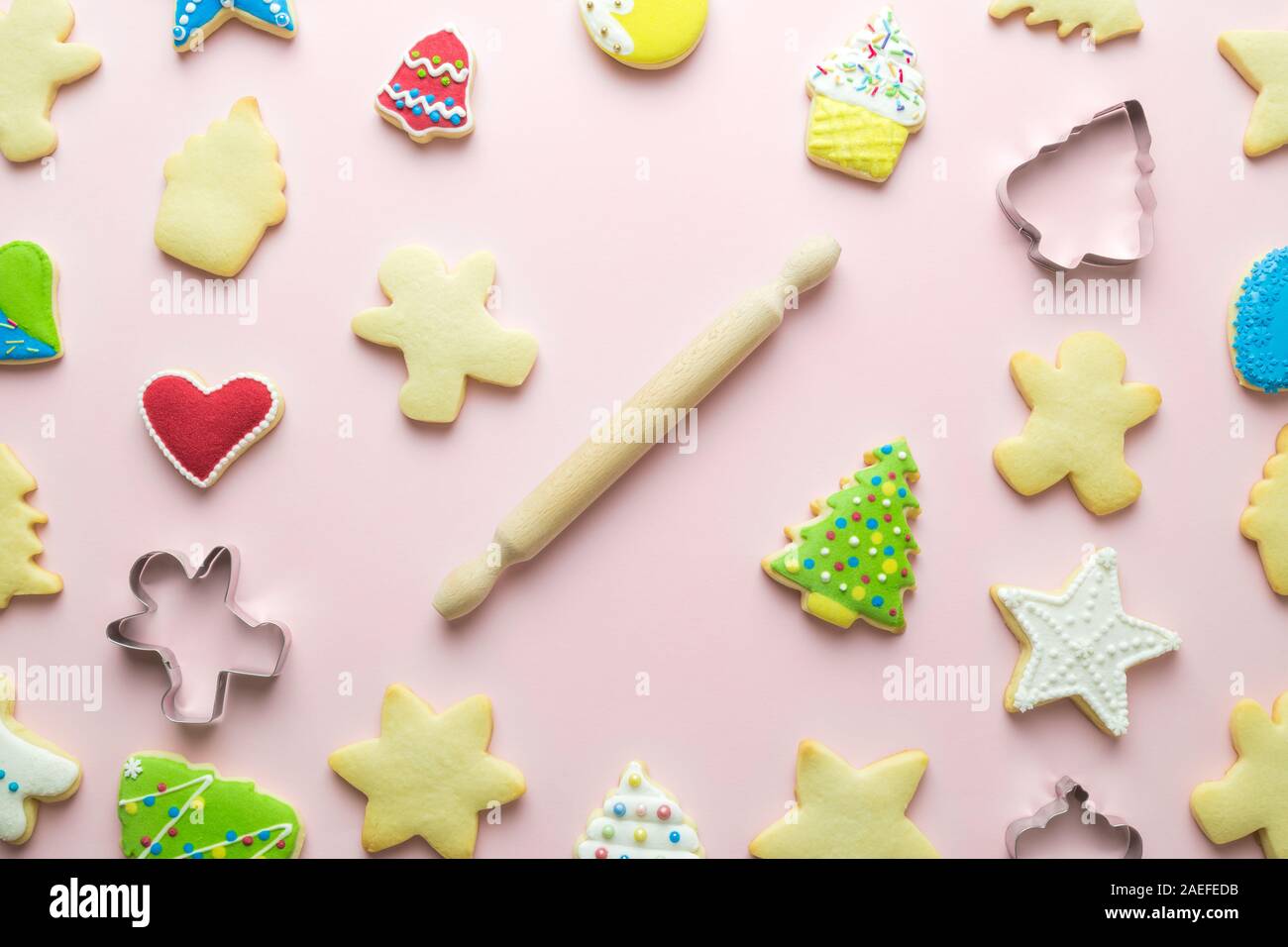 Lay piatto biscotti di Natale pattern e perno di rotolamento sul rosa pastello sfondo vacanza minimo concetto creativo. Foto Stock