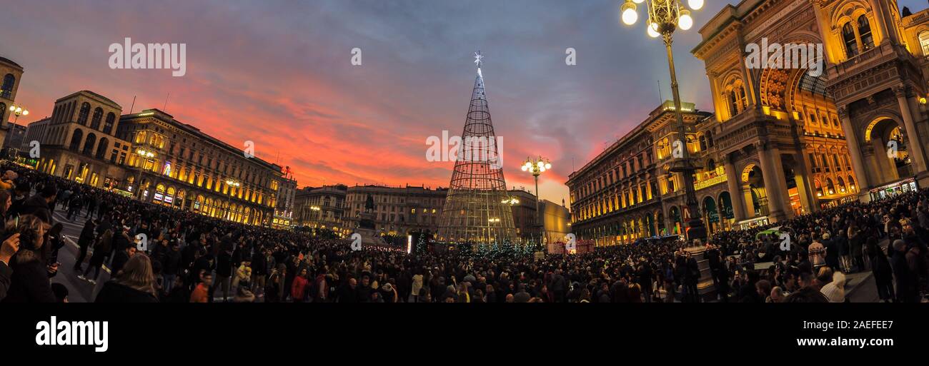 Milano, Italia - 7 dicembre 2019 Panoramica di una folla di persone in visita a Piazza Duomo a Milano con il rispettivo albero di Natale Illuminazione al crepuscolo Foto Stock