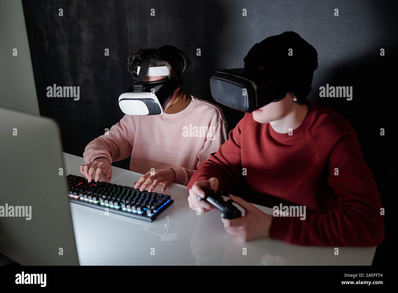 Due adolescenti contemporaneo in vr auricolari i giochi per computer Foto Stock