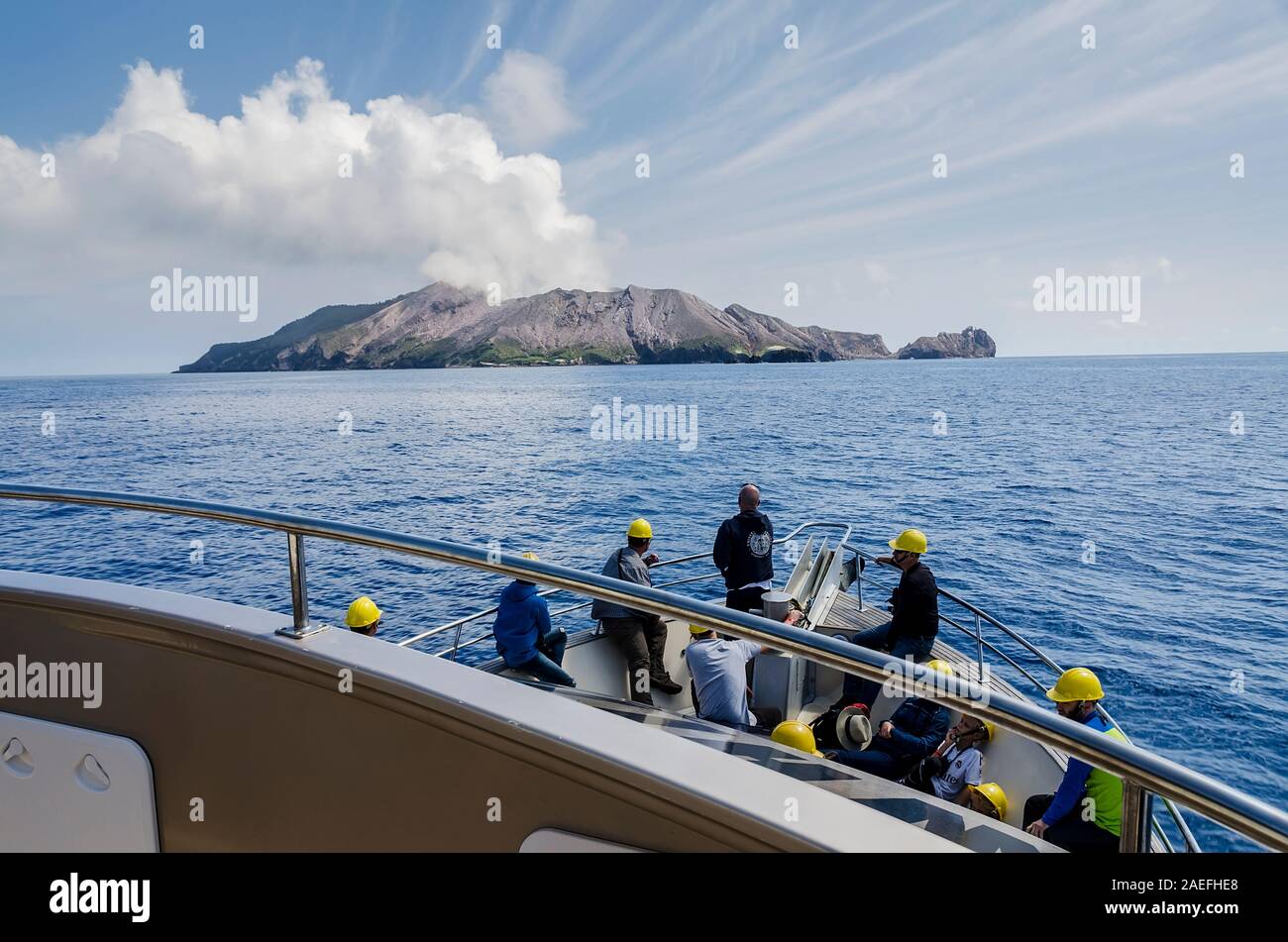 Barca turistica che va verso l'Isola Bianca, con il fumo che si può fumare dal vulcano attivo Foto Stock