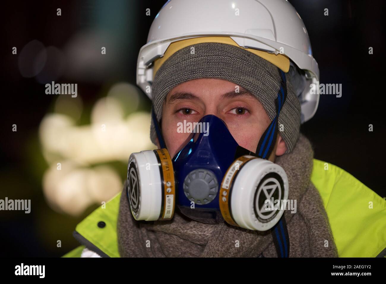 Londra, Regno Unito. 09Dec, 2019. Estinzione della ribellione 'aria che abbiamo Grieve' manifestante protesta ha lanciato un pre-alba azione nel centro di Londra per protestare illegale di livelli di qualità dell'aria nella capitale. Vestito come autostrada gli addetti alla manutenzione hanno bloccato Cranbourne St e incollato stessi di blocchi in calcestruzzo anche incollata alla strada Credito: Gareth Morris/Alamy Live News Foto Stock