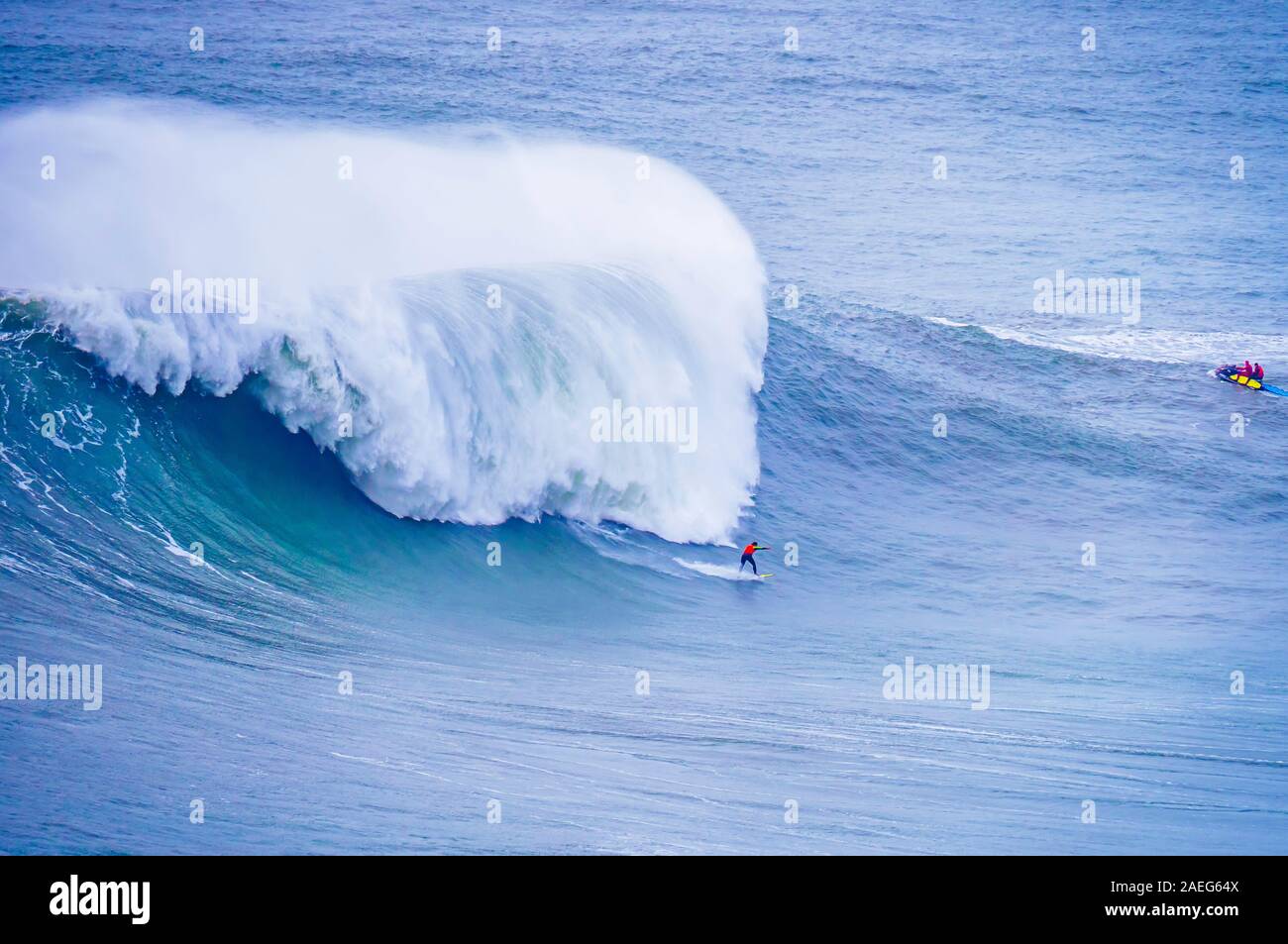 Surfer surf onde enormi a Nazare Portogallo Foto Stock