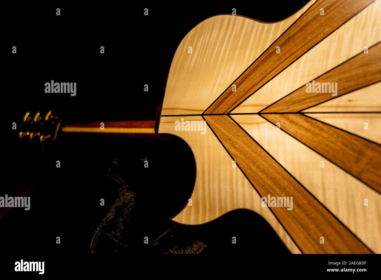La geometrica indietro di un fatto a mano la chitarra su uno sfondo nero. Foto Stock
