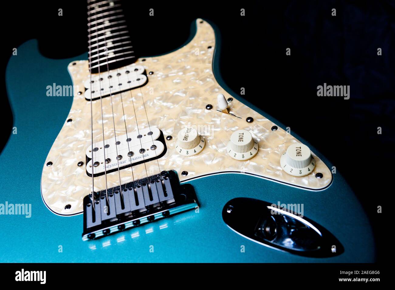 A dettagli di una luce blu chitarra elettrica su uno sfondo nero. Foto Stock