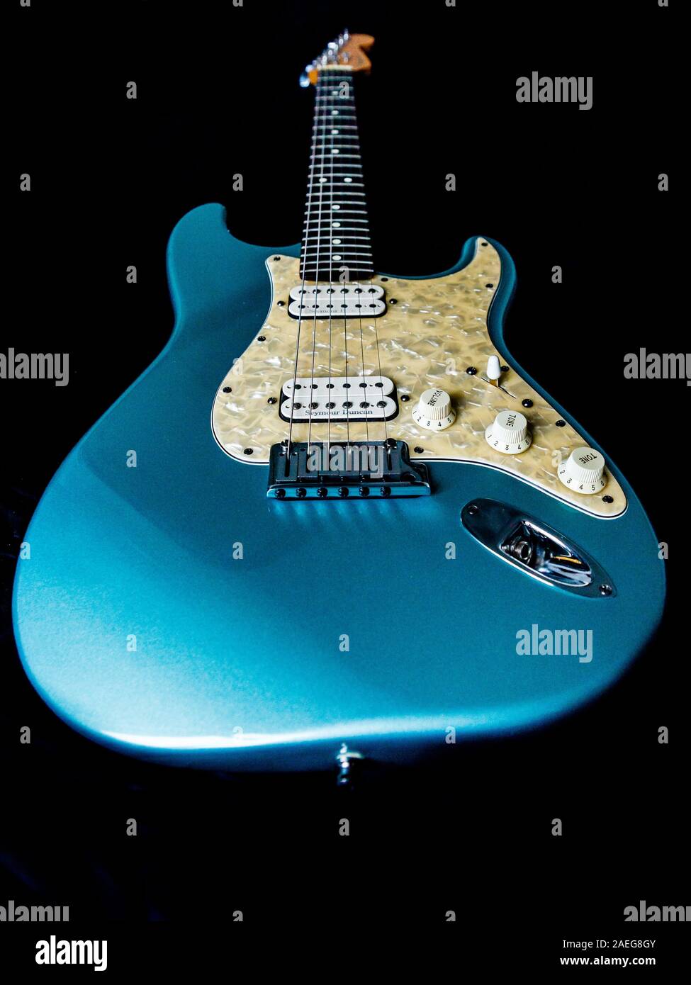 Luce blu chitarra elettrica su sfondo nero da basso punto di vista. Foto Stock