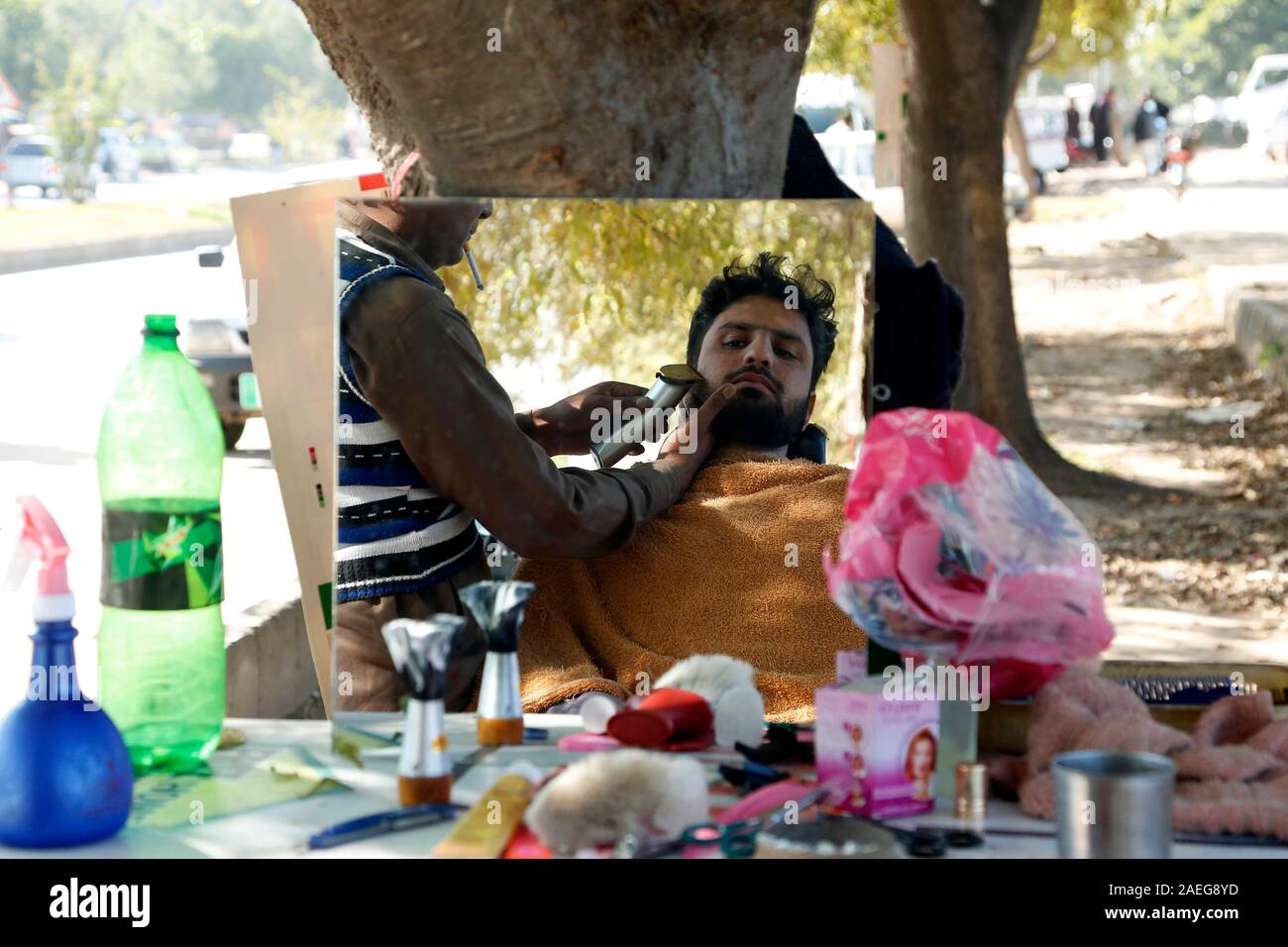 (191209) -- ISLAMABAD, Dicembre 9, 2019 (Xinhua) -- una strada i rivestimenti del barbiere barba del suo cliente a Islamabad, la capitale del Pakistan, Dicembre 4, 2019. (Xinhua/Ahmad Kamal) Foto Stock