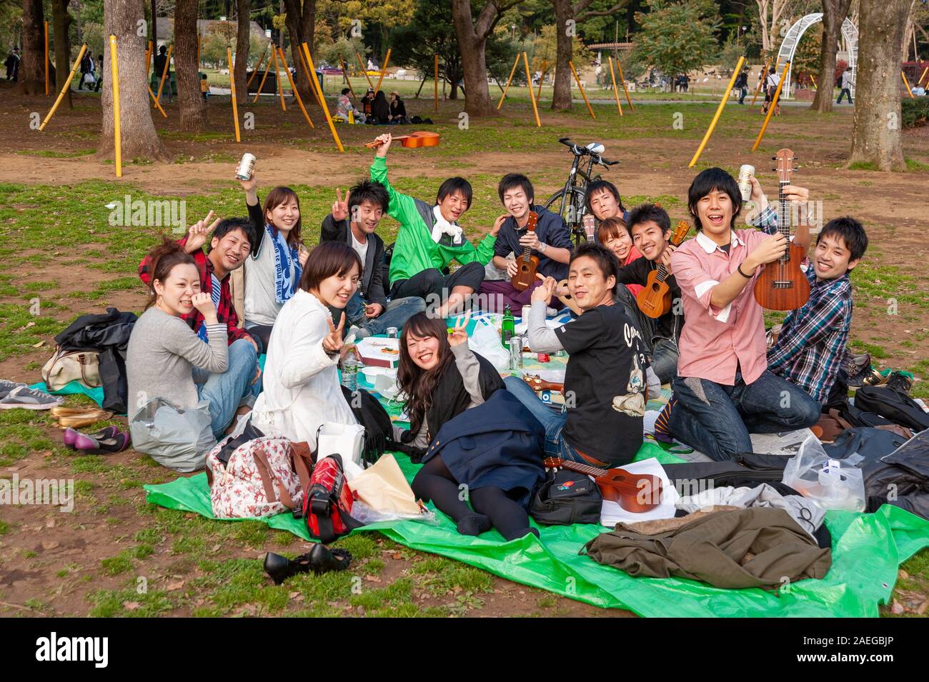 Gli adolescenti avente picnic hanami chiamato a Yoyogi Park, Tokyo, Giappone Foto Stock