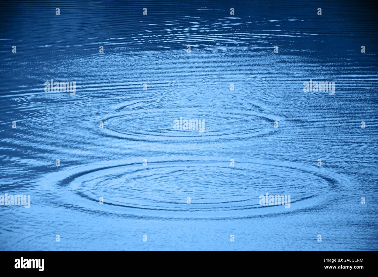 Due circoli ondulata sull'acqua e riflessioni. Foto Stock