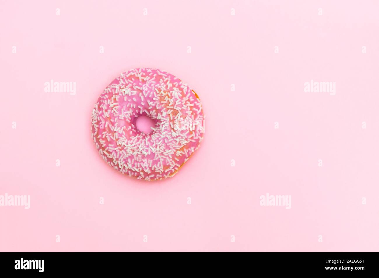 Vista superiore della rosa ciambella smaltata su soft rosa sullo sfondo della carta Foto Stock