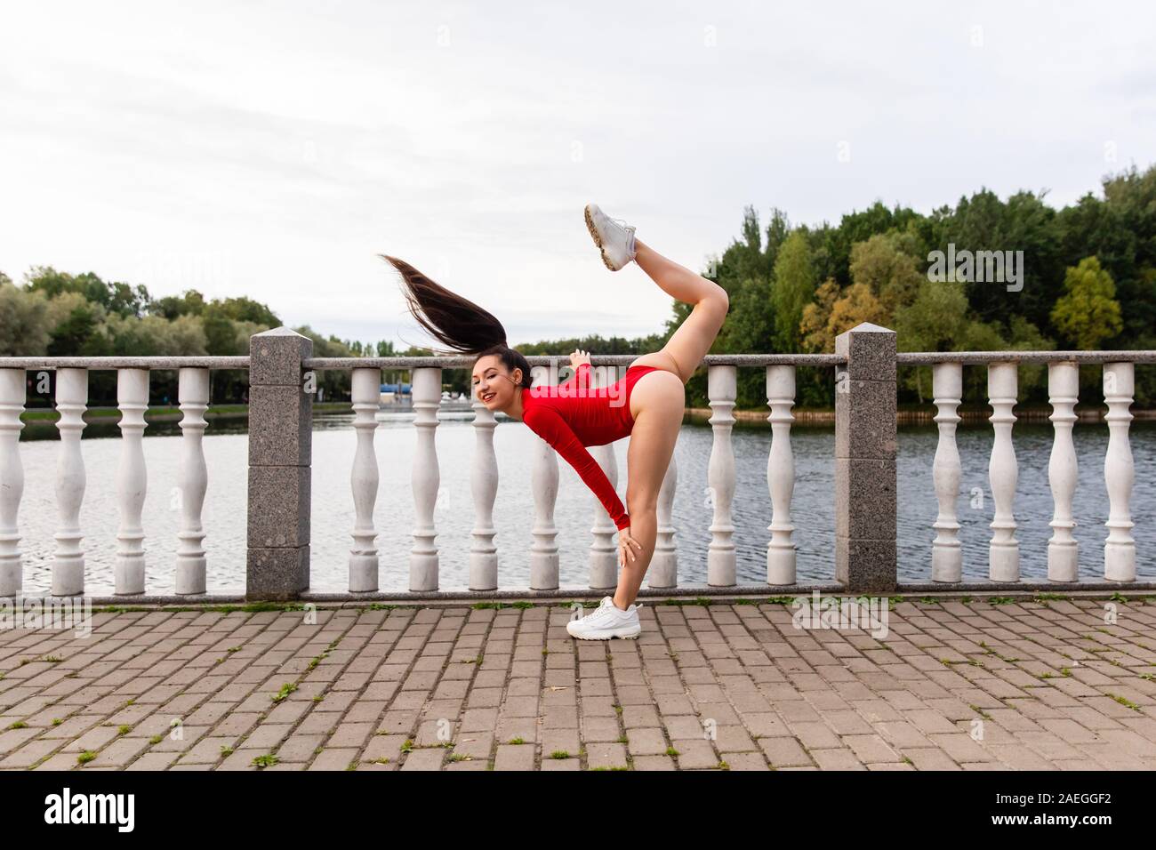 Bella ragazza atleta facendo stretching nel parco Foto Stock