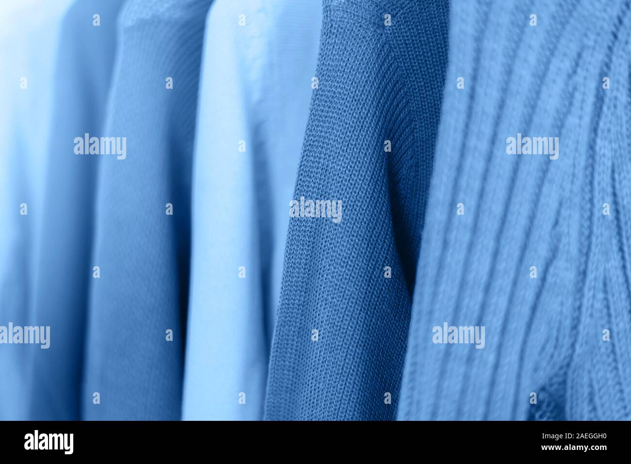Riga di tessuto lavorato a maglia maglioni caldi onhangers tonalità di colore blu. Foto Stock