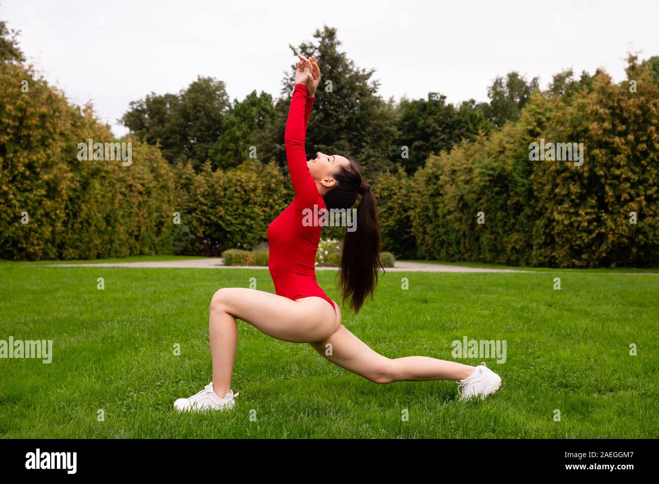 Bella ragazza atleta facendo stretching nel parco Foto Stock