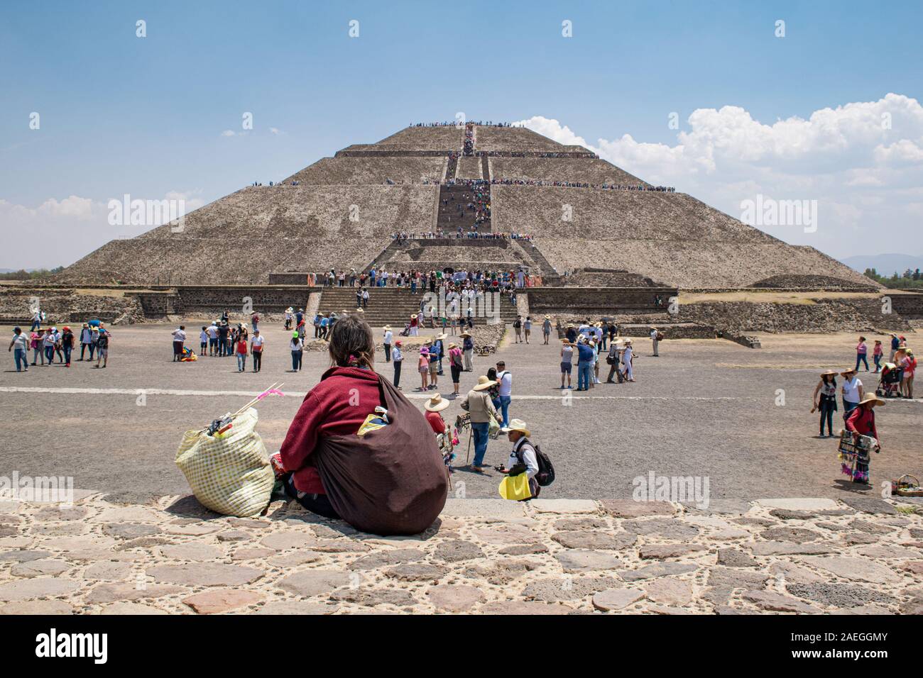 Souvenir locali di riposo del venditore, guardando la folla di turisti salendo la Piramide del Sole a Teotihuacan sito archeologico. Foto Stock