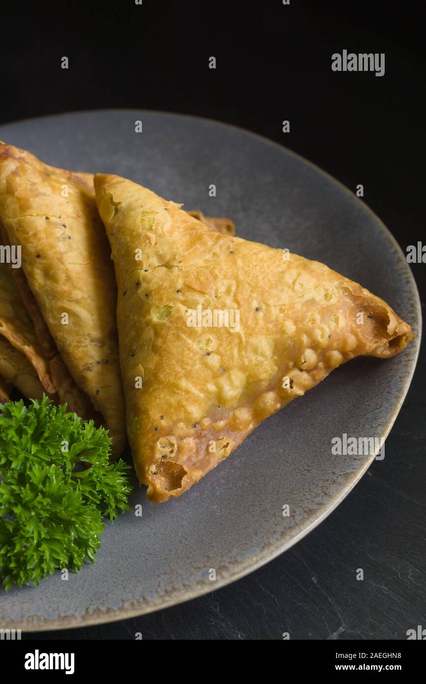 Samosa una piccante miscela di verdure o di carne avvolti in un profondo fritto pasticceria triangolare pacco un popolare snack nel Medio Oriente e in Asia del Sud Foto Stock