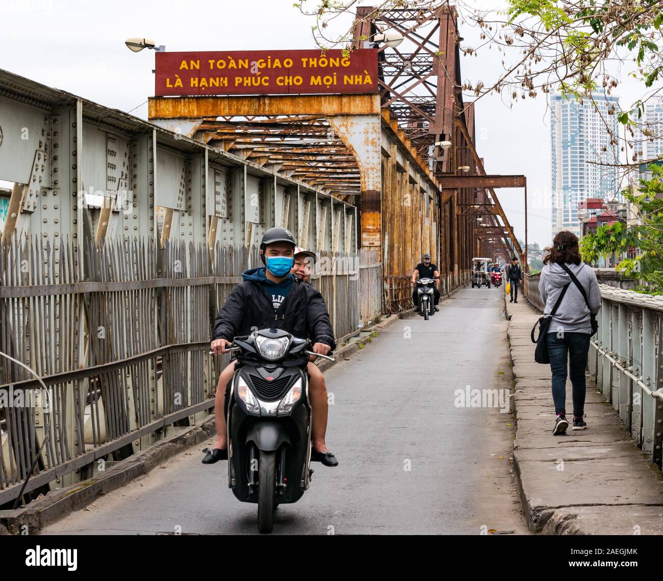 Matura in sella motocicletta su Long Bien bridge, Red River, Hanoi, Vietnam, sud-est asiatico Foto Stock