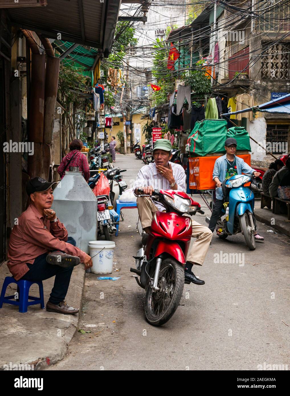 Gli uomini in moto in strada stretta corsia, Hanoi, Vietnam, sud-est asiatico Foto Stock