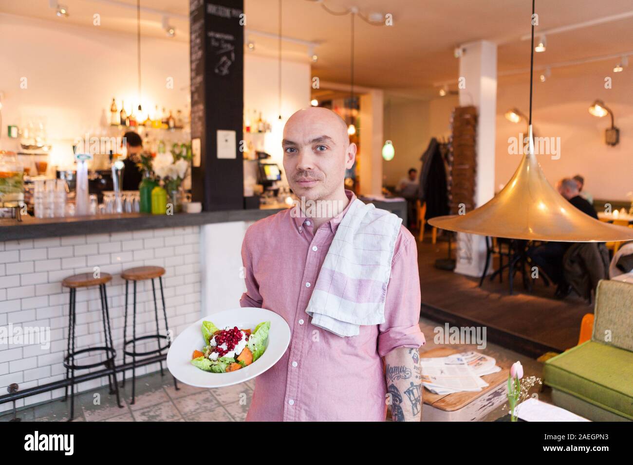 Cameriere che tiene un piatto al Bar Spek, Amsterdam, Paesi Bassi Foto Stock