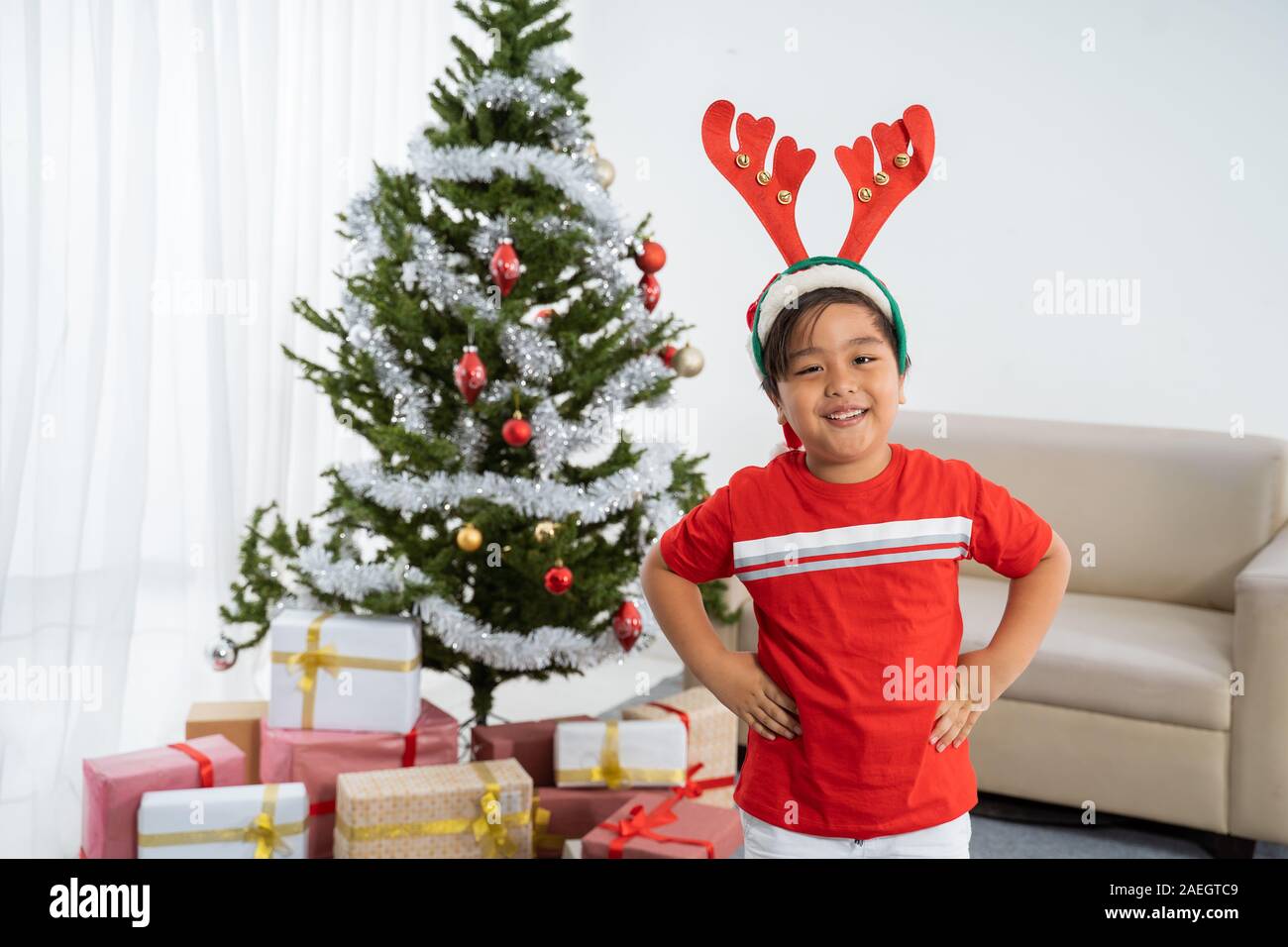 Felice asian madre mise santa hat sul suo figlio Foto Stock