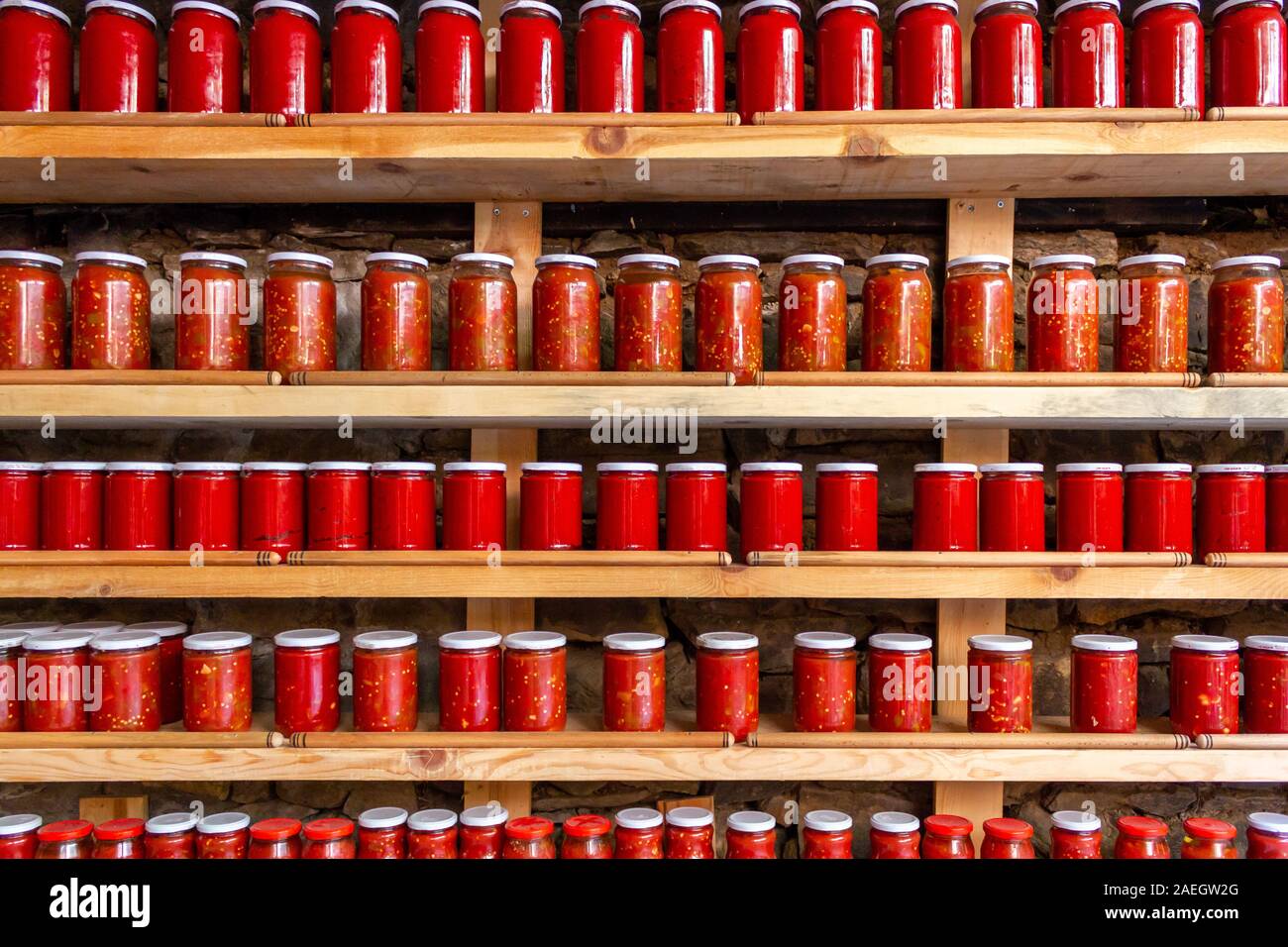 Pomodori e pepe pasta in vasi. La pasta di pomodoro vasetti allineati sui ripiani. Salsa di pomodoro e peperone Foto Stock