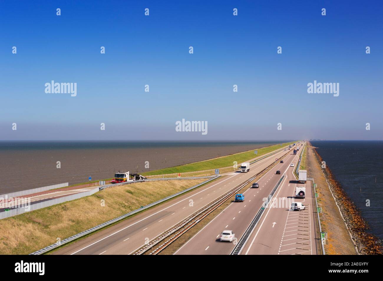 Il traffico sulla Afsluitdijk in una giornata di sole nei Paesi Bassi. La Afsluitdijk è una diga su 32km damming off Zuiderzee, una di acqua salata Foto Stock