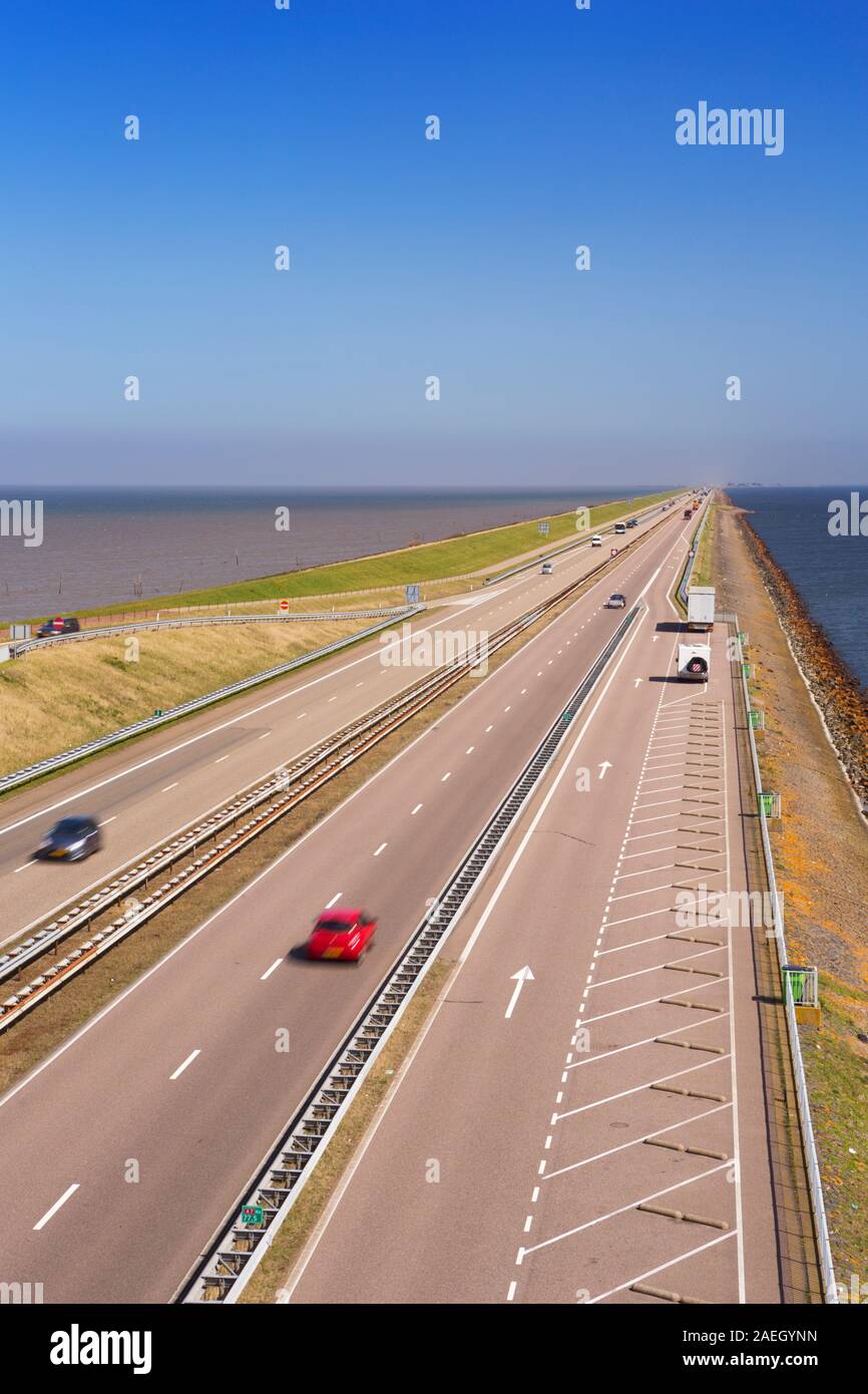 Il traffico sulla Afsluitdijk in una giornata di sole nei Paesi Bassi. La Afsluitdijk è una diga su 32km damming off Zuiderzee, una di acqua salata Foto Stock