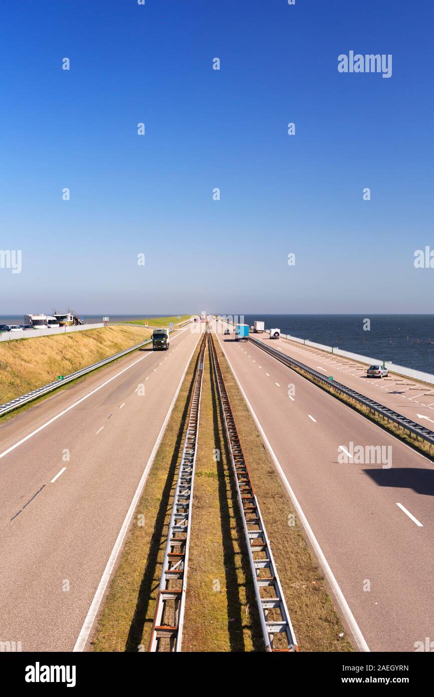Il traffico sulla Afsluitdijk in una giornata di sole nei Paesi Bassi. La Afsluitdijk è una diga su 32km damming off Zuiderzee, una di acqua salata Foto Stock