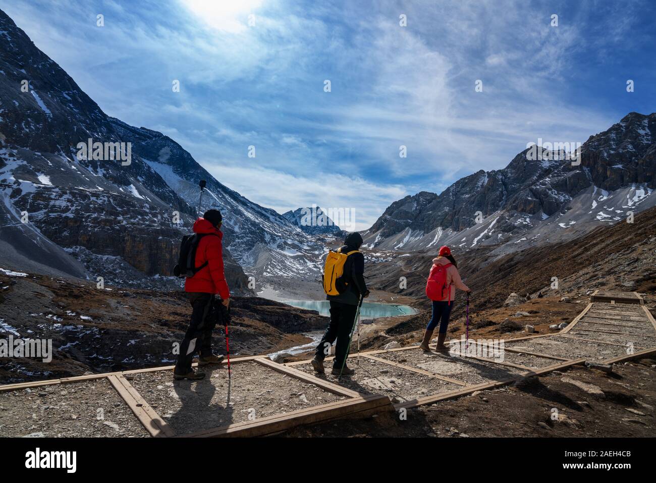 Tre turisti trekking a piedi l'iceberg in Cina Yading del parco. Essi sono forti per il lago lattiginoso e cinque-lago colorati. Foto Stock