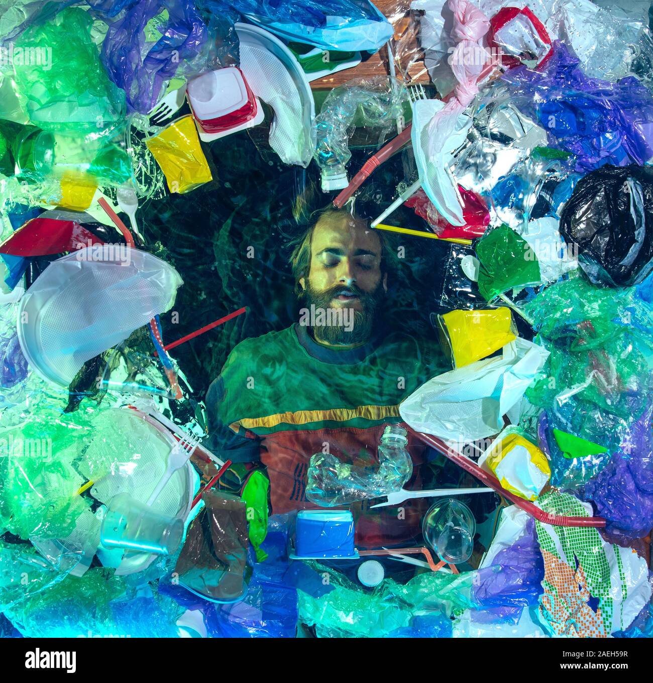 L'uomo annegamento in acqua sotto plastica destinatari pila, garbage. Utilizzate bottiglie e pacchi di riempimento oceano mondiale uccisione di persone. Ecologia, Ambiente concetto, plastica e vetro inquinamento, natura disastro. Foto Stock