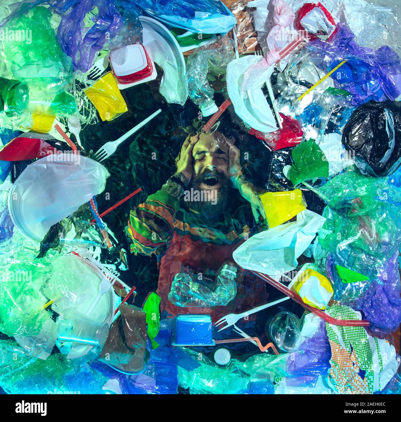 L'uomo annegamento in acqua sotto plastica destinatari pila, garbage. Utilizzate bottiglie e pacchi di riempimento oceano mondiale uccisione di persone. Ecologia, Ambiente concetto, plastica e vetro inquinamento, natura disastro. Foto Stock