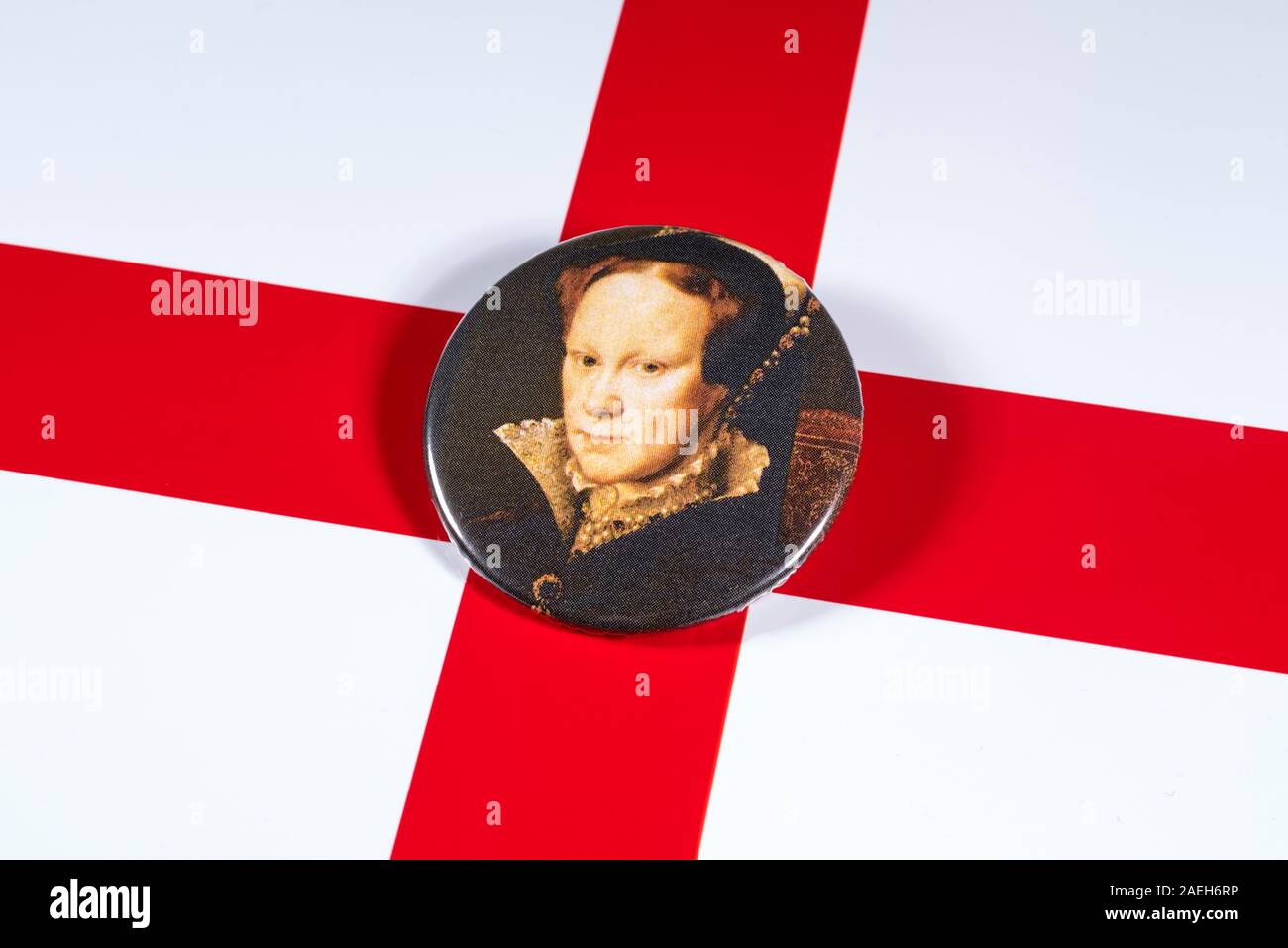 London, Regno Unito - 5 Dicembre 2019: un pin distintivo della Regina Maria I, noto anche come Bloody Mary, nella foto sopra la bandiera dell'Inghilterra. Foto Stock