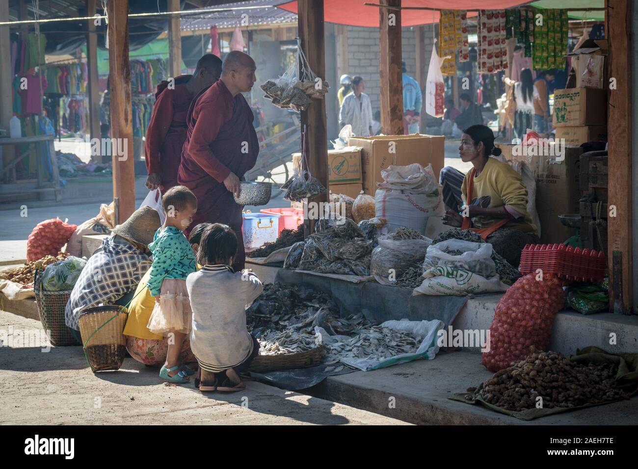 I monaci buddisti donazione raccolta da un negozio locale proprietario al settimanale mercato alimentare di Loikaw. Questa è una pratica comune in Myanmar. Foto Stock