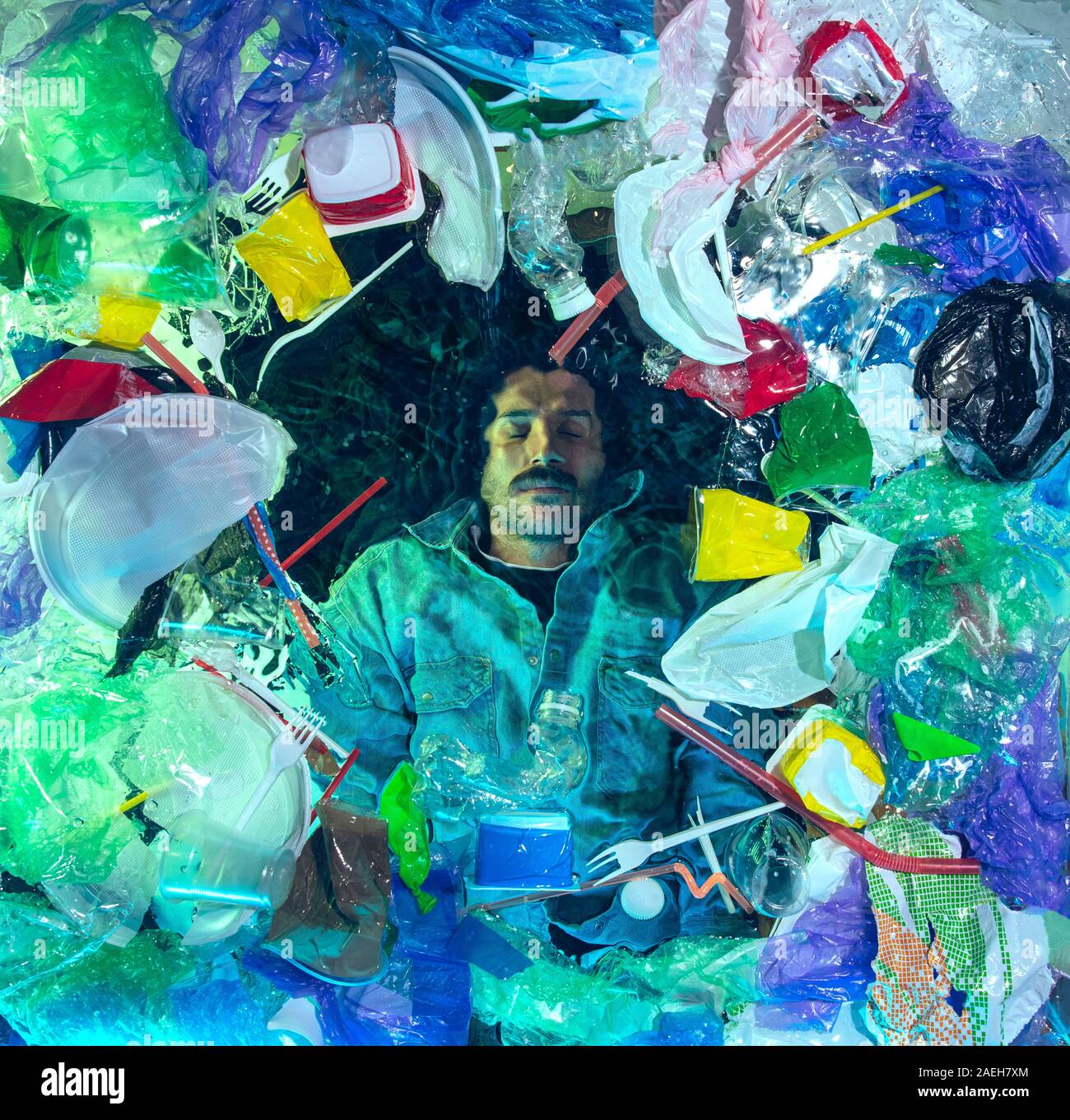 L'uomo annegamento in acqua sotto plastica destinatari pila, garbage. Utilizzate bottiglie e pacchi di riempimento oceano mondiale uccisione di persone. Ecologia, Ambiente concetto, plastica e vetro inquinamento, natura disastro. Foto Stock