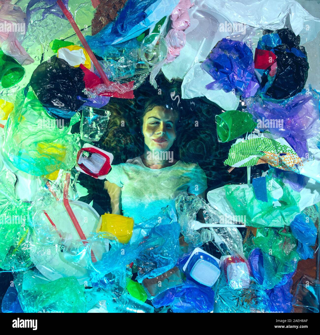 Donna annegamento in acqua sotto plastica destinatari pila, garbage. Utilizzate bottiglie e pacchi di riempimento oceano mondiale uccisione di persone. Ecologia, Ambiente concetto, plastica e vetro inquinamento, natura disastro. Foto Stock