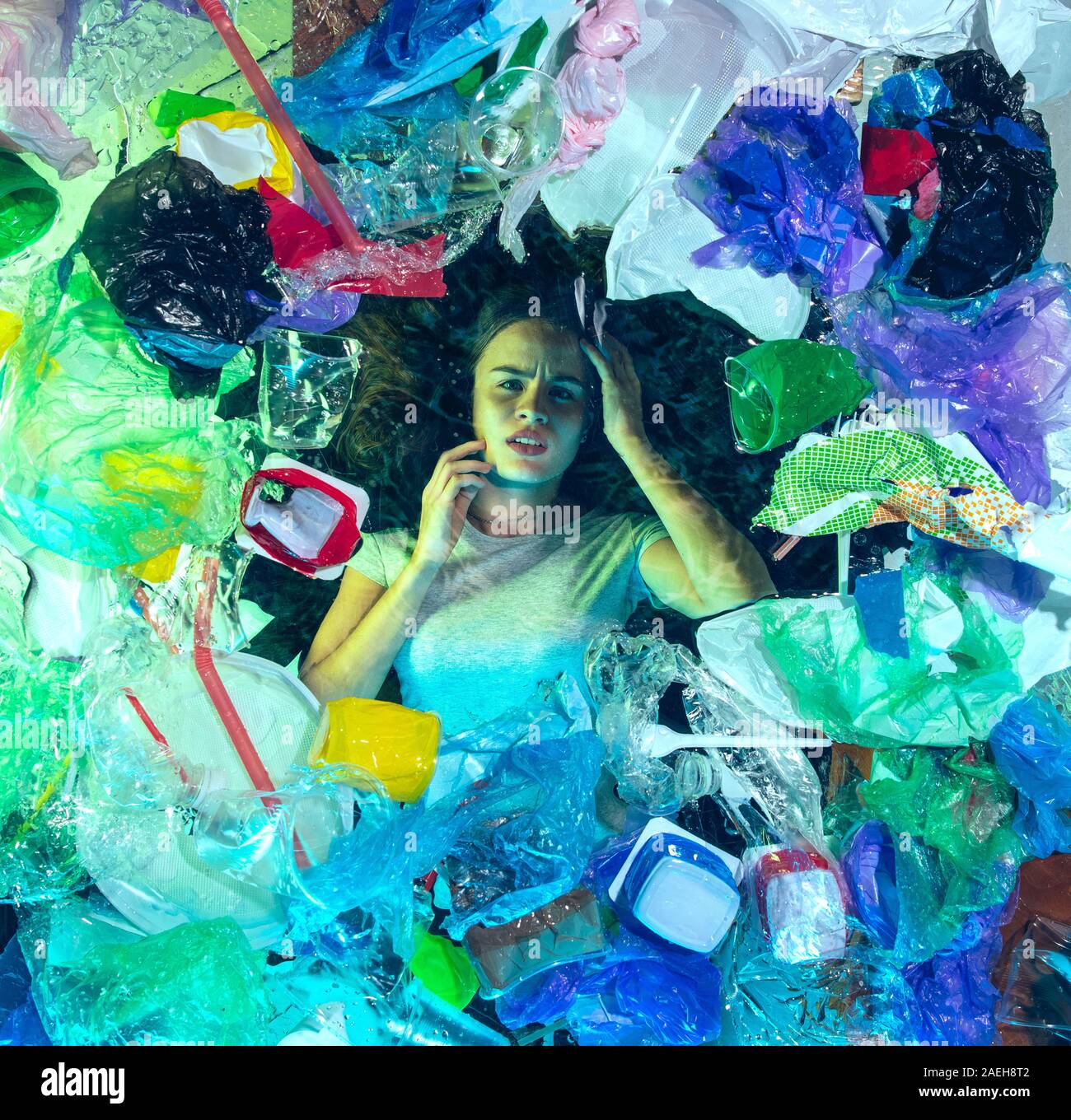 Donna annegamento in acqua sotto plastica destinatari pila, garbage. Utilizzate bottiglie e pacchi di riempimento oceano mondiale uccisione di persone. Ecologia, Ambiente concetto, plastica e vetro inquinamento, natura disastro. Foto Stock