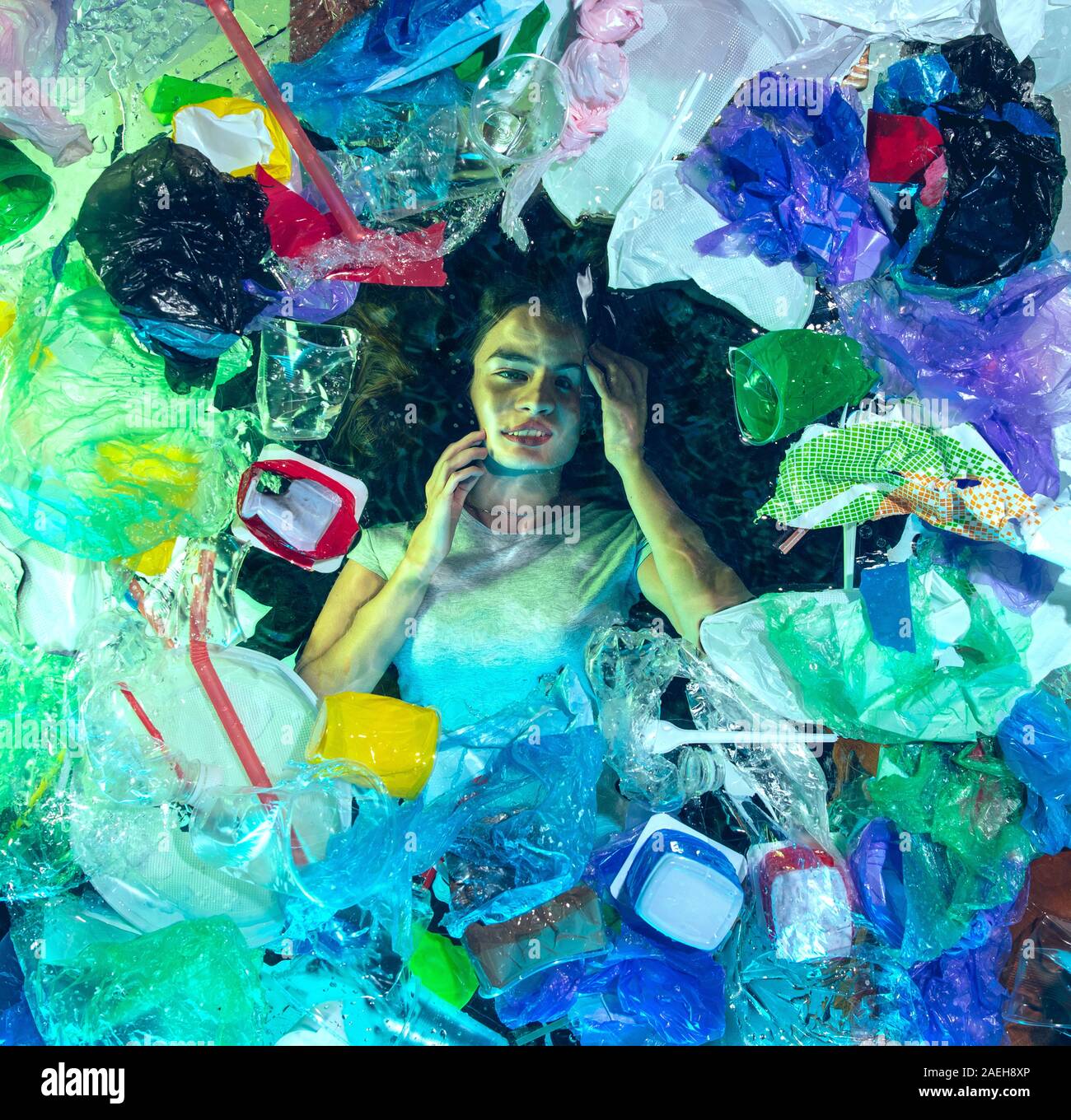 Donna annegamento in acqua sotto plastica destinatari pila, garbage. Utilizzate bottiglie e pacchi di riempimento oceano mondiale uccisione di persone. Ecologia, Ambiente concetto, plastica e vetro inquinamento, natura disastro. Foto Stock