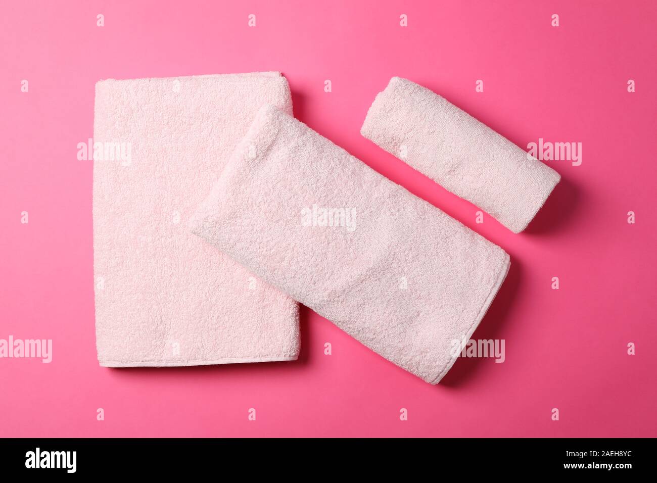 Composizione con asciugamani piegati su sfondo rosa, vista dall'alto Foto Stock