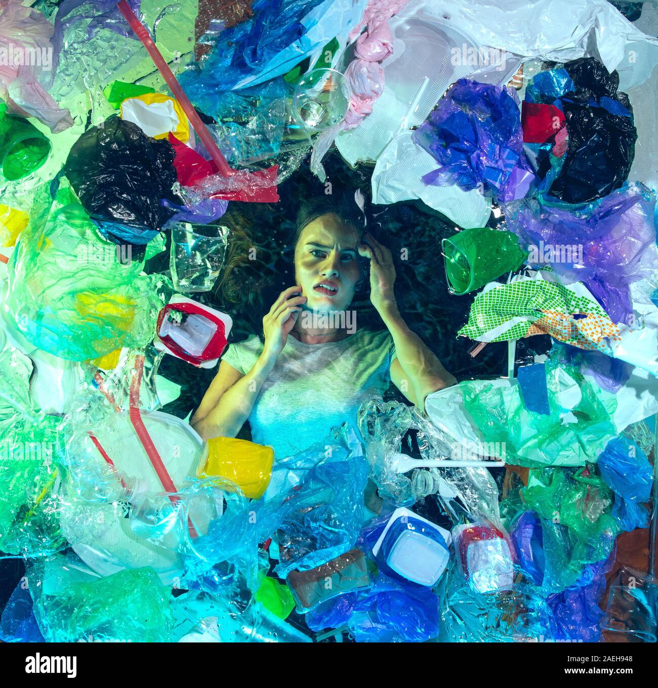 Donna annegamento in acqua sotto plastica destinatari pila, garbage. Utilizzate bottiglie e pacchi di riempimento oceano mondiale uccisione di persone. Ecologia, Ambiente concetto, plastica e vetro inquinamento, natura disastro. Foto Stock