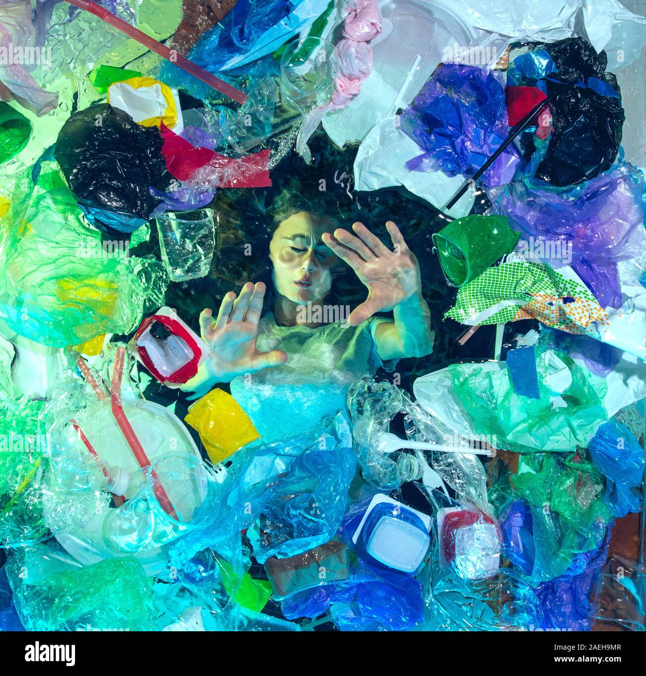 Donna annegamento in acqua sotto plastica destinatari pila, garbage. Utilizzate bottiglie e pacchi di riempimento oceano mondiale uccisione di persone. Ecologia, Ambiente concetto, plastica e vetro inquinamento, natura disastro. Foto Stock