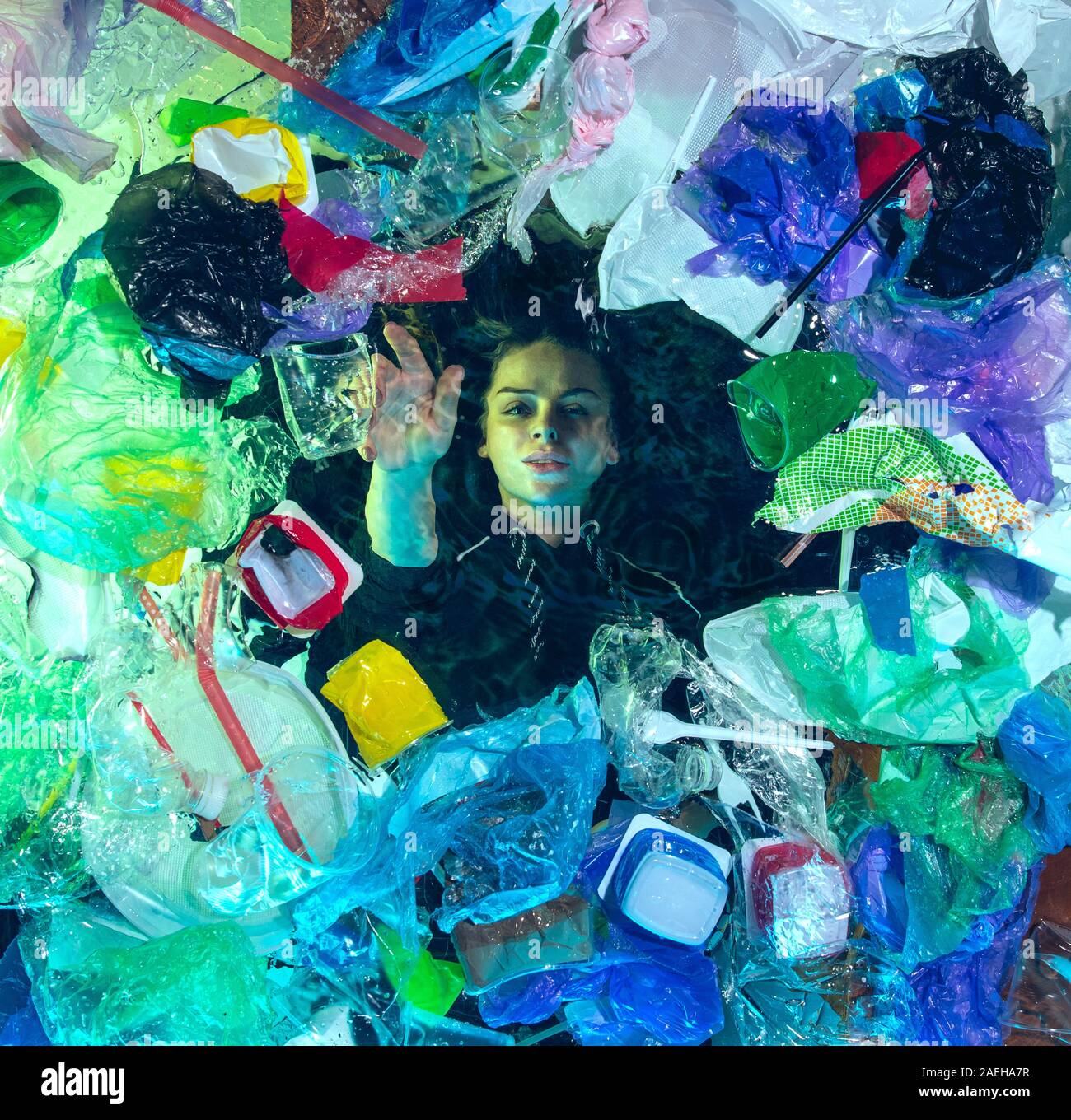 Donna annegamento in acqua sotto plastica destinatari pila, garbage. Utilizzate bottiglie e pacchi di riempimento oceano mondiale uccisione di persone. Ecologia, Ambiente concetto, plastica e vetro inquinamento, natura disastro. Foto Stock