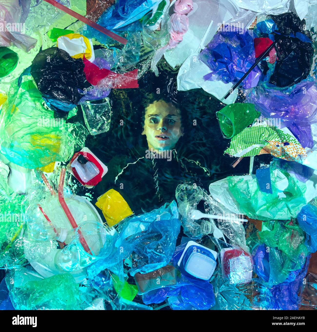 Donna annegamento in acqua sotto plastica destinatari pila, garbage. Utilizzate bottiglie e pacchi di riempimento oceano mondiale uccisione di persone. Ecologia, Ambiente concetto, plastica e vetro inquinamento, natura disastro. Foto Stock