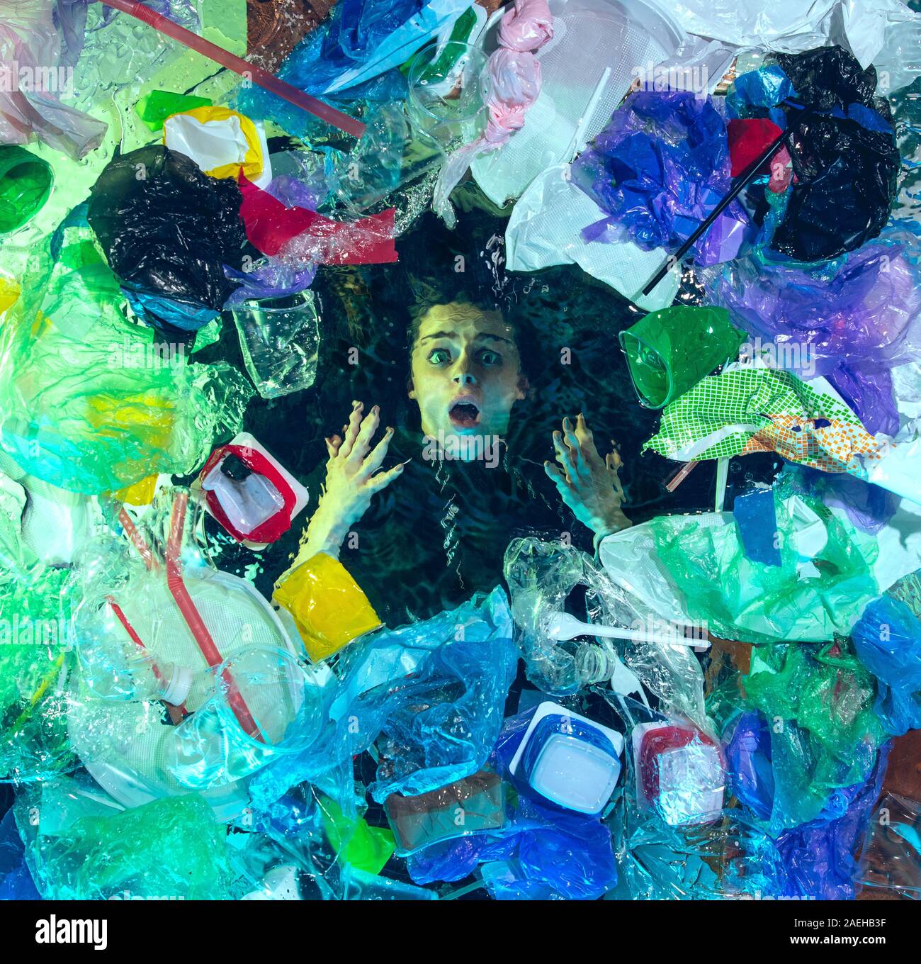 Donna annegamento in acqua sotto plastica destinatari pila, garbage. Utilizzate bottiglie e pacchi di riempimento oceano mondiale uccisione di persone. Ecologia, Ambiente concetto, plastica e vetro inquinamento, natura disastro. Foto Stock