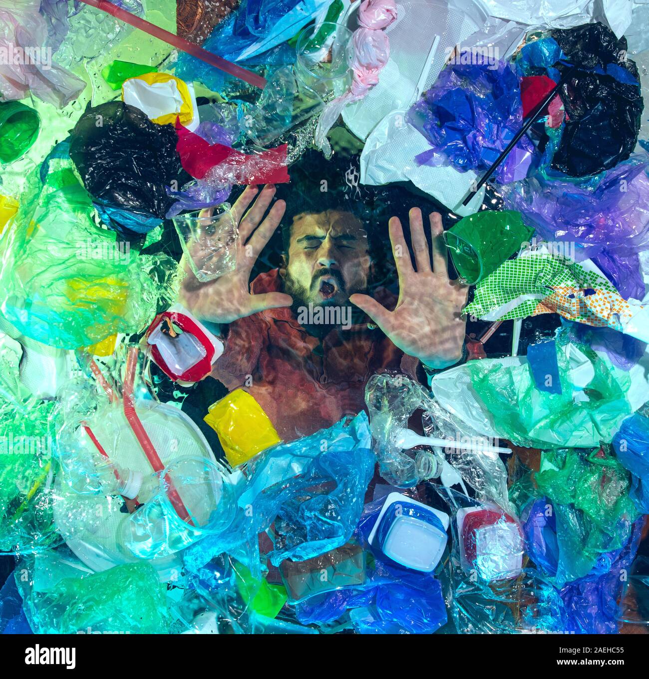 L'uomo annegamento in acqua sotto plastica destinatari pila, garbage. Utilizzate bottiglie e pacchi di riempimento oceano mondiale uccisione di persone. Ecologia, Ambiente concetto, plastica e vetro inquinamento, natura disastro. Foto Stock